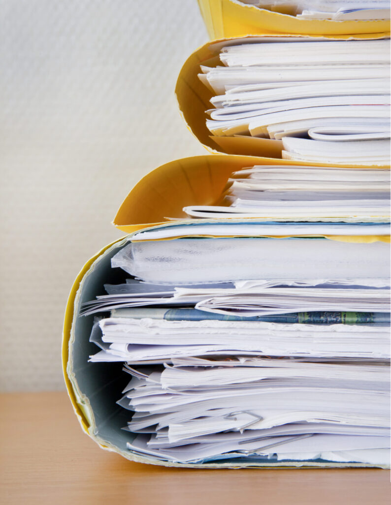 Stack of papers for manual data entry.
